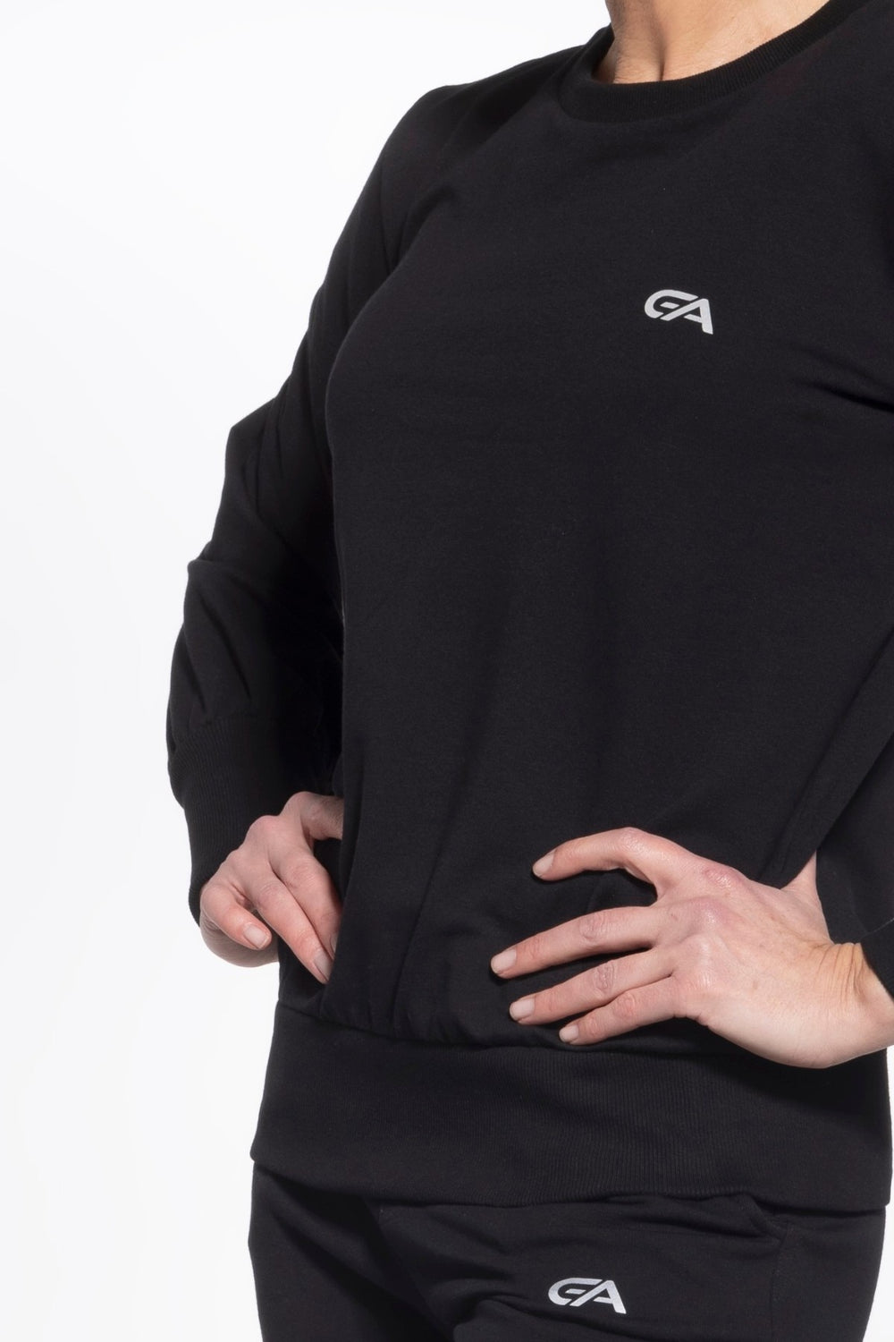 Person wearing a black long-sleeve shirt with a logo on a white background