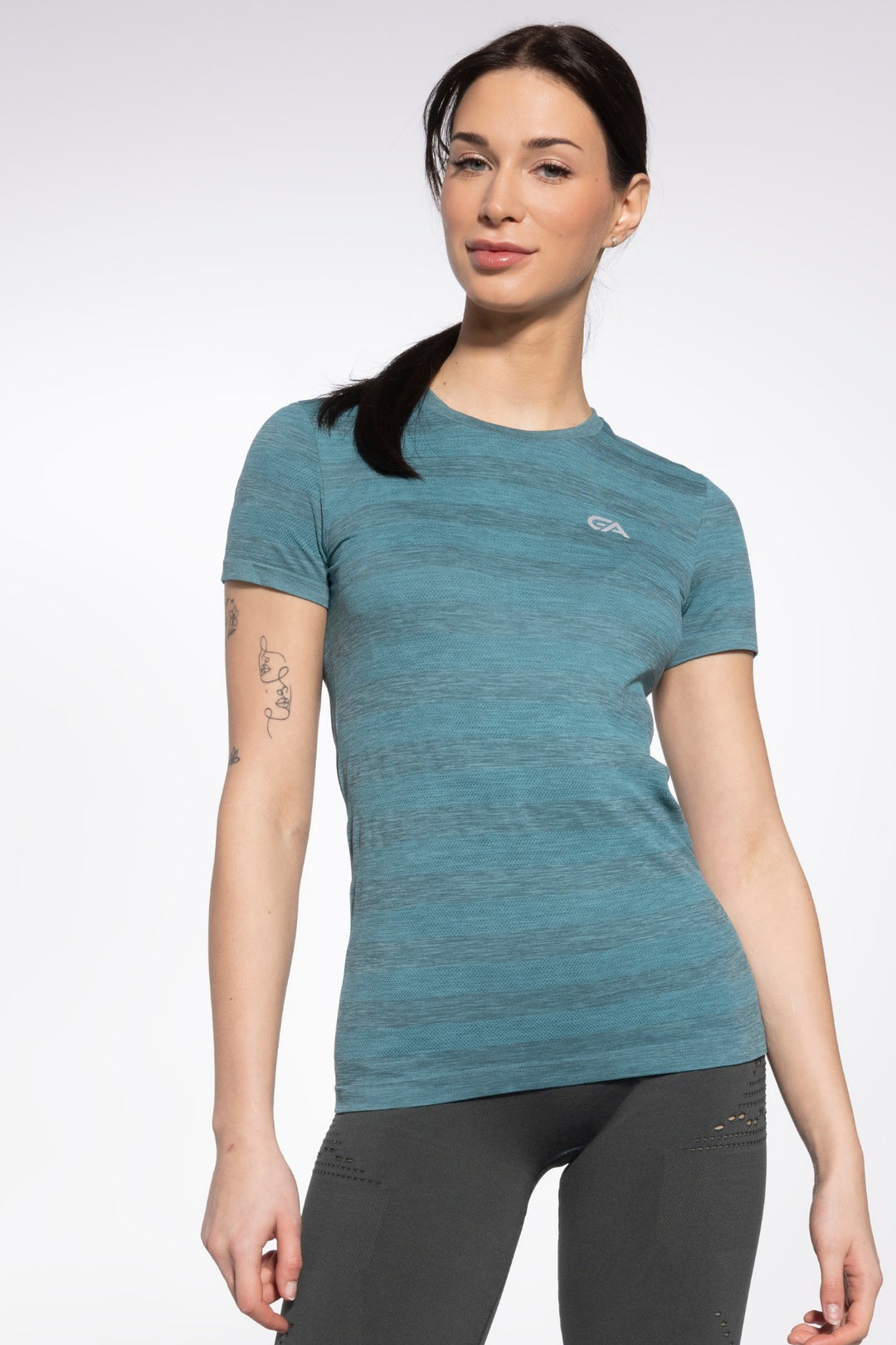 Woman athlete in green sport T-shirt with a slim, athletic cut and ventilated fabric, built for running, gym training, or casual activewear