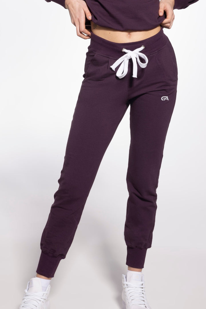 Purple moisture-wicking sport sweatpants with wide elastic cuffs at the ankles, offering a snug fit and enhanced mobility for workouts