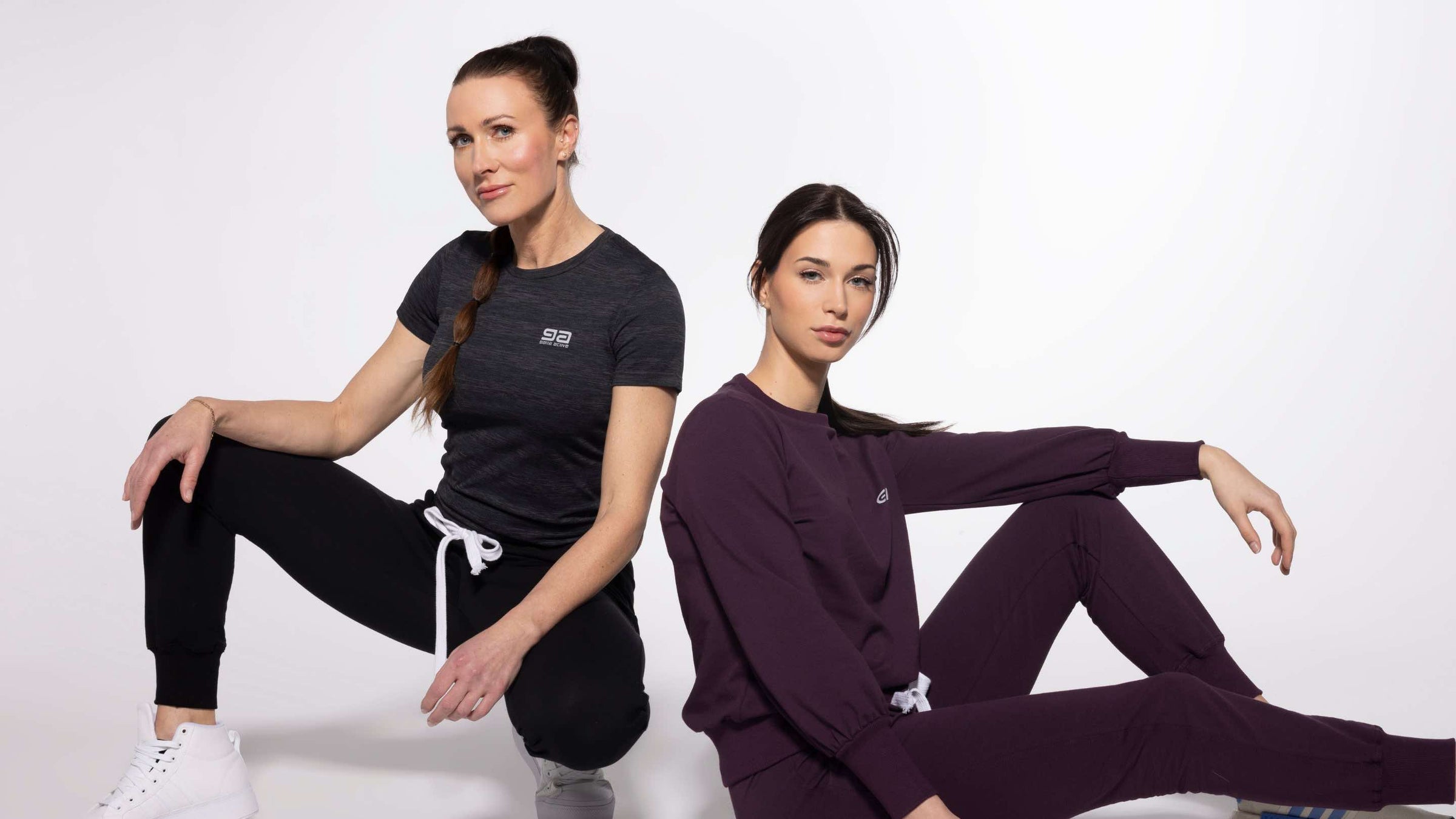Two women in casual activewear – one in sweatpants and sweatshirt, the other in sport t-shirt and sweatpants