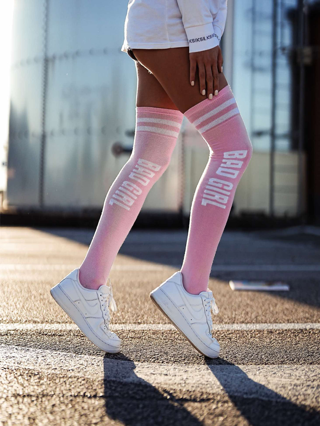 Women’s powder pink cotton over-the-knee socks with Bad Girl pattern. Soft, breathable socks perfect for stylish, bold, and comfortable wear.