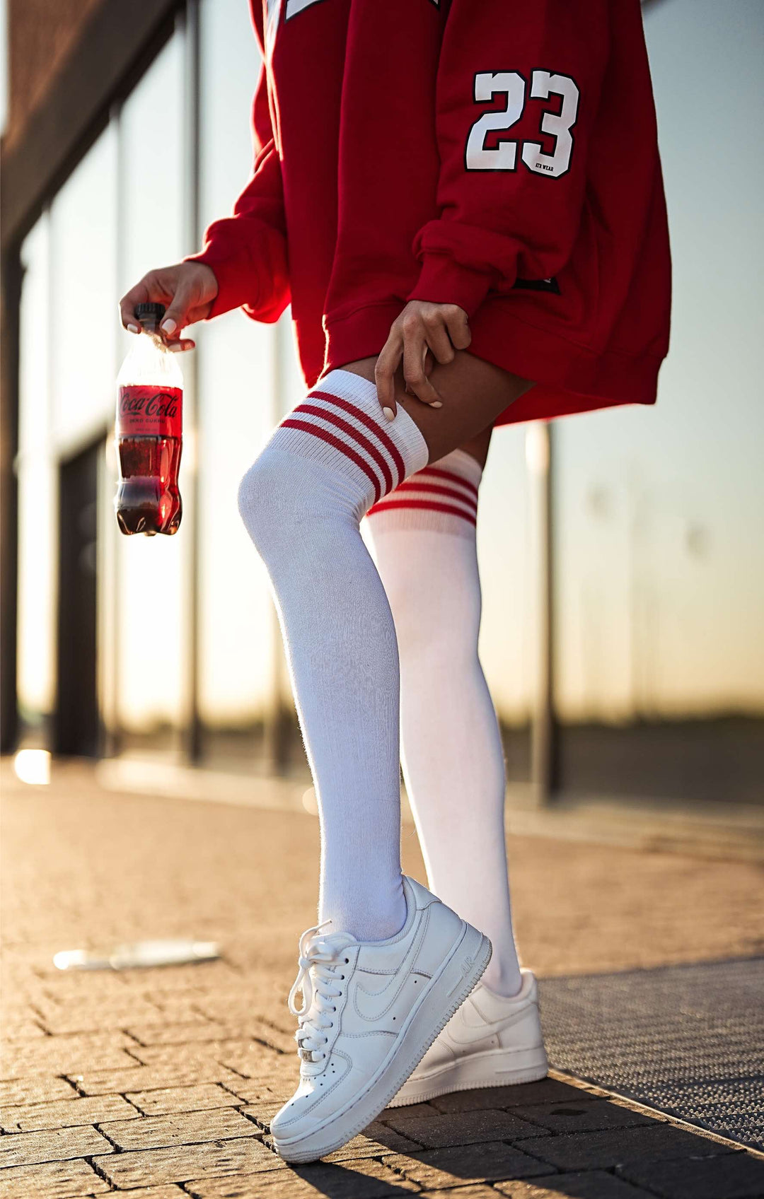 White cotton over knee socks with vibrant red striped welt, adding a pop of color to any outfit