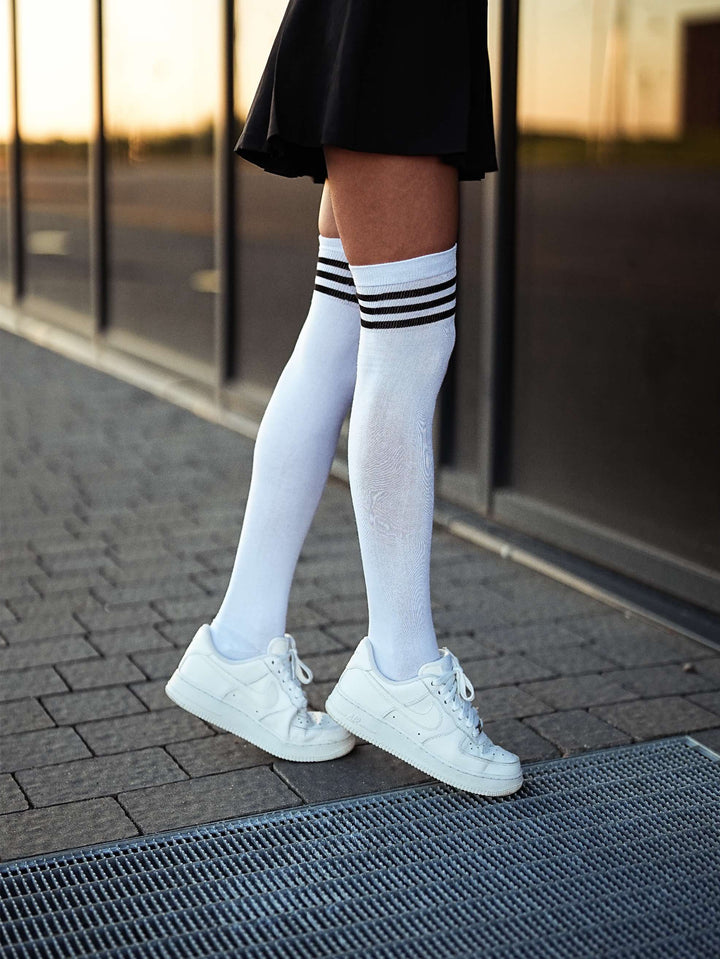 Women’s white over-the-knee socks with bold black striped welt, ideal for casual or dressy looks