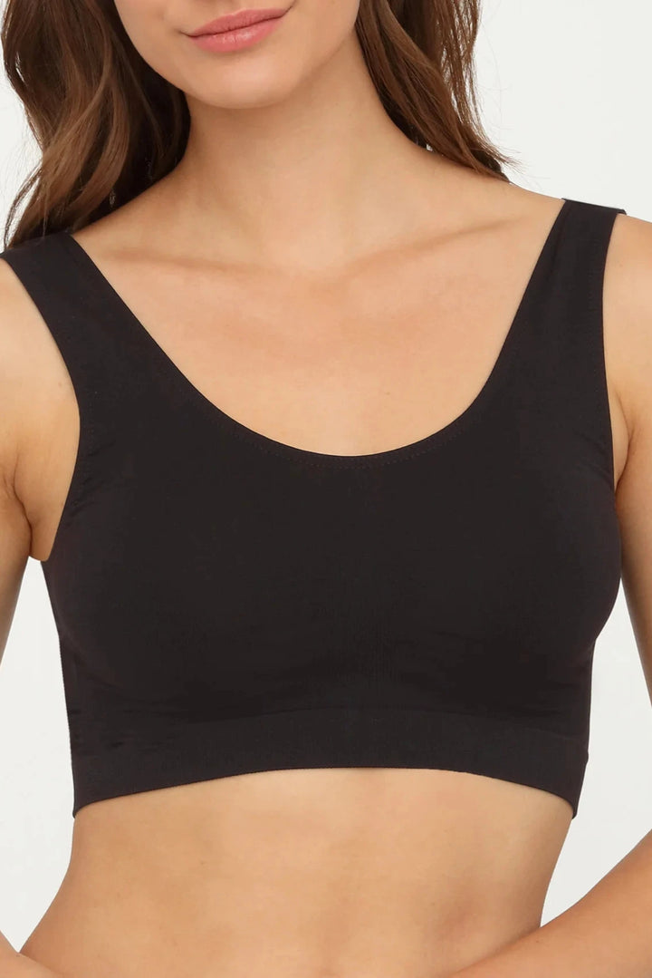 Black sports top with seamless design, wide straps, and stretchy, airy fabric for optimal comfort and natural movement